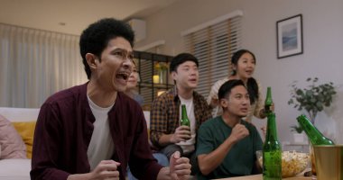 Bir grup yetişkin erkek ve kadın arkadaş, Asya halkı kanepeye oturur, eğleniriz, eğleniriz, oyun oynarız, FIFA dünya kupası canlı yayını izleriz, atıştırmalık şeyler yeriz, bira şişesi şişesi atlarız, çılgın mutlu oluruz, mutlu oluruz.