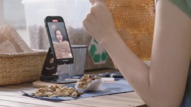 KOBİ 'nin sahibi yeşil net sıfır perakende mağazasından canlı yayında çevre koruma plastiksiz paketleme kutusunu gösteriyor. Asyalı genç kadın tiktok IG bobinli Instagram 'da video kaydı yapıyor..