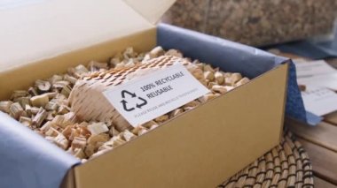Net zero waste go green SME use eco friendly care sign plastic free symbol packaging carton box wrap paper in small shop retail store. Chva dried water hyacinth on desk reuse packing parcel supplies.