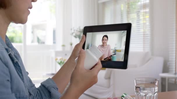 営業サービスビデオ電話の呼び出し後の幸せなアジアの専門家の女性Crmアプリは自宅で助言を助けます アジアの人々精神医療センター販売ハーブビタミン薬製品オンライン笑顔デジタルタブレット上の話 — ストック動画