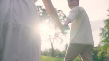 Back rear view young lover asia people happy smile trust hold hand enjoy relax walk way forward to sun light. Just married asian man woman in nature field begin family dream of life love hope and care