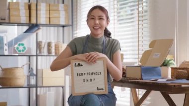 Go green vendor use eco care packaging box in net zero waste store asian seller retail home office shop. Small SME owner young adult woman asia Gen Z people happy relax smile pride looking at camera.
