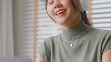 Taking a break work relax easy listen music joy sing a song at cozy home good time life balance remote WFH job. Mental health care enjoy fun dance reduce stress relief in Gen Z asia people young woman