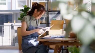 Eco vendor go green packaging parcel carton box in net zero waste store asian seller retail shop. Earth care day small SME owner asia people wrap reuse brown paper pack gift reduce plastic free order.