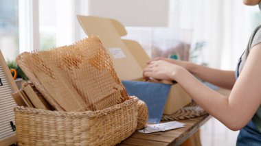 Eco vendor go green packaging parcel carton box in net zero waste store asian seller retail shop. Earth care day small SME owner asia people wrap reuse brown paper pack gift reduce plastic free order.
