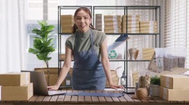 Go green vendor use eco packaging parcel carton box in net zero waste store asian seller retail home office shop. Small SME owner young adult woman asia Gen Z people happy smile pride look at camera.