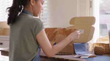 Eco vendor go green packaging parcel carton box in net zero waste store asian seller retail shop. Earth care day small SME owner asia people wrap reuse brown paper pack gift reduce plastic free order.