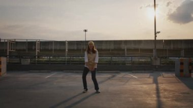 Young active Gen Z asia girl crazy humor fun full length hip hop dance sport at car park lot public metro rail train. Funny people woman happy joy relax in urban city life with sun light enjoy music.