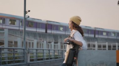 Yeşil net sıfır temiz düşük enerjili eko sürüş motor e-scooter itin. Asya insanları genç bayan Gen Z mutlu şehir hayatı modern halk treniyle rahat rahat gülümse..