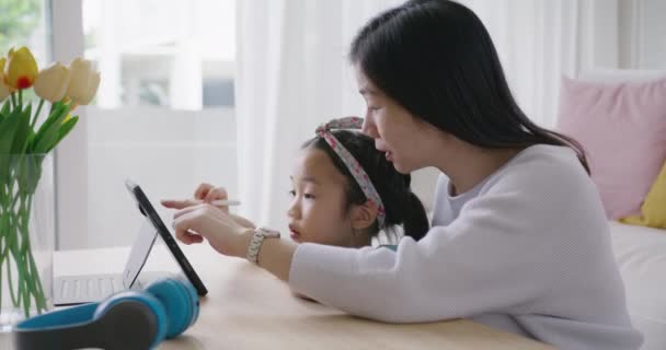 かわいいアジアの人々アルファ小さなGen Z子供の楽しいトークプレイは 家庭用ソファでお母さんとスマートタブレットアプリゲームで学びます 子供のケアの女の子とお母さんの幸せな笑顔をお楽しみくださいリラックス教師スキルアップアイデアオンラインクラス — ストック動画