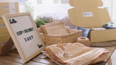 Net zero waste go green SME use eco friendly care sign plastic free symbol packaging carton box wrap paper in small shop retail store. Chva dried water hyacinth on desk reuse packing parcel supplies.