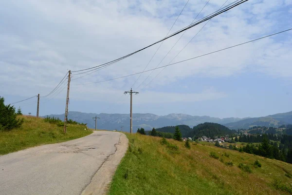 Kırsal yollar, tepe manzarası ve mavi gökyüzü.