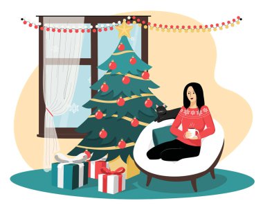 Kız ve kedi rahat bir sandalyede oturmuş Noel için hediyeler ve süslemelerle bekliyorlar.