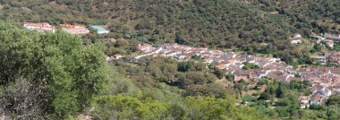 Alajar, Huelva, İspanya, 23 Nisan 2023: Alajar kasabasının Sierra de Aracena 'daki evlerinin salgını 850 metre yükseklikteki dağların arasından görülmektedir.