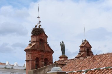 Aracena, Huelva, İspanya, 12 Haziran 2023: 16. yüzyıl Nuestra Senyora del Carmen Kilisesi 'nin çatısında leylekler ve Bakire Meryem resmi olan Belfries. Aracena, Huelva, İspanya