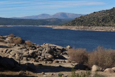 El Burguillo Reservoir, Avila, İspanya, 13 Kasım 2023: El Burguillo Barajı 'ndaki bitki örtüsü, dağlar ve büyük taşlar, Avila, İspanya