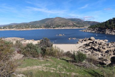 El Burguillo Reservoir, Avila, İspanya, 13 Kasım 2023: El Burguillo Reservoir, Avila, İspanya 'daki bitki örtüsünün, dağların ve büyük taşların manzarası