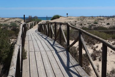 Salinas El Pinet, La Marina, Alicante, İspanya, 10 Nisan 2024: Salinas del Pinet, La Marina, Alicante, İspanya 'nın kumsal rotasındaki tahta patika