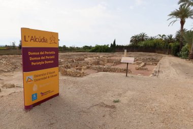 Ilici - La Alcudia, arkeolojik alan. Elche, Alicante, İspanya, 19 Haziran 2024: Ilici-La Alcudia arkeoloji sahasındaki Peristyle 'ın Roma domusunun kalıntılarının yanında bilgi işareti. Elche, Alicante, İspanya