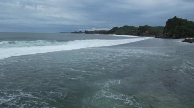 Güzel sahil suyu dalgaları kayalık kayalıkları, ağaçları, denizi, sakin atmosferi, manzarayı dalgalandırır.