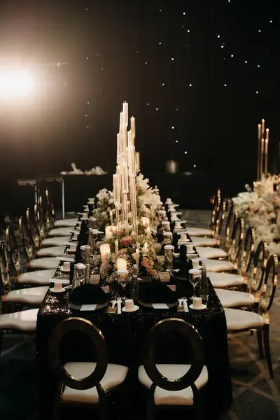 Lüks düğün sofrası ve çiçek ve mumlarla süslenmiş sandalye.