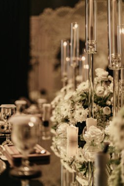 Çiçekler ve mumlarla süslü bir düğün sofrası süsü.