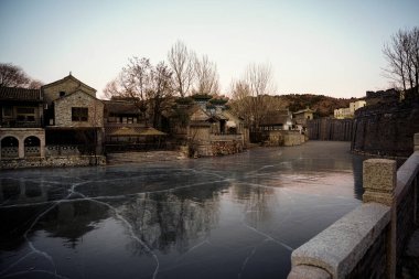 Nehir tepeler ve evler arasında akar, manzara