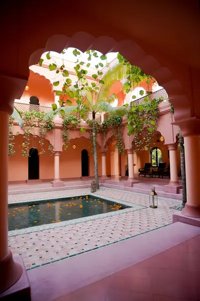 Havuzu, ağaçları ve lambaları olan pembe bina tasarımı. Bali, Endonezya - 26 Haziran 2023 (2)