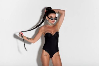 Siyah iç çamaşırlı şehvetli genç bir kadın. Renkli fiziğini ve uzun saçlarını gösteriyordu. Çekici bir stüdyo ortamında.