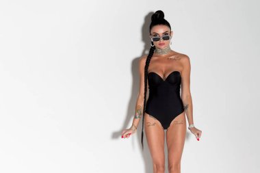 İnce silueti ve çarpıcı uzun saçları olan zarif bir bayan. Ateşli siyah iç çamaşırlarıyla çekici pozlar veriyor. Sıcak tonlu bir stüdyo seansında yakalandı.