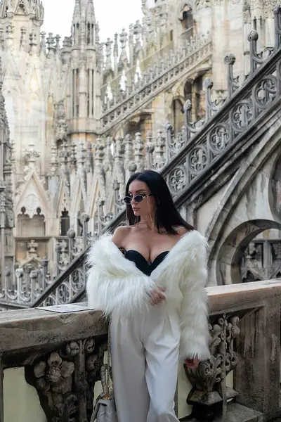 Şehir keşfi: Zarafet ve zarafeti simgeleyen beyaz kürkü ile şık bir genç kadın, Milano Katedrali 'nin çatısında güven içinde poz veriyor