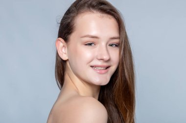 Genç bir kadının berrak, parıldayan teninin güzelliğinden zevk aldığı bir huzur anı. Güzellik salonları ve kaplıca reklamları için ideal..