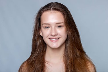 Yüzüne dokunan ışıl ışıl genç bir kadınla teninin dinginliğini keşfedin. Güzellik ve sağlık başyazıları için ideal..