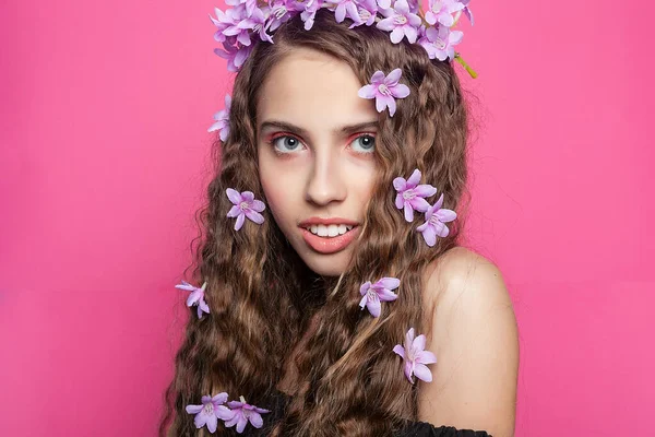 优雅的女孩展示着她的卷发 上面点缀着精致的紫色花朵 散发着一种迷人而浪漫的气息 图库图片