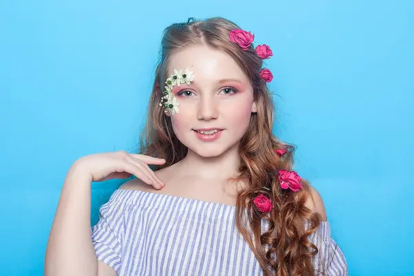 ポジティブな女の子 青い背景に彼女の手のデイジーを持つ小さな女の子 子供は花を持ち 神秘的に微笑んでいる グリーティングカード ストック画像