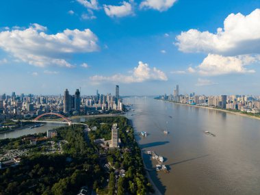 Wuhan Çin sehri berrak mavi gökyüzünün altında görkemli Yangtze Nehri boyunca yayılır. Binalar ve yeşil alanlar akan nehirle harmanlanarak canlı kent manzarasını sergiliyor..