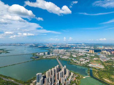 Jiangxia Bölgesi, Wuhan, Çin 'deki Tangxun Gölü, açık mavi gökyüzü altında geniş bir şehir siluetini gösteren bu geniş hava manzarası ile gözler önüne serildi..