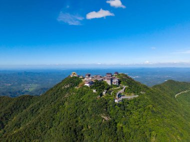 Suizhou Şehri Hubei Çin 'de yemyeşil bir dağın tepesinde geniş mavi gökyüzü ile antik tarz binalar bulunmaktadır..