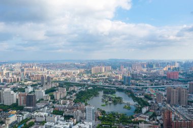 Wuhan şehri ufka doğru uzanır, Yangtze Nehri 'ni bulutlu bir gökyüzünün altında kucaklayan geniş bir metropol..