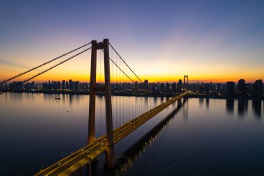 Wuhan şehir köprüsü gün batımında şehrin manzarasını gösteriyor..