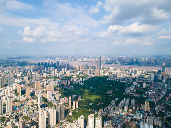 Современный уханский городской пейзаж разворачивается с течением реки Янцзы, показывая обширный городской пейзаж под облачным небом.