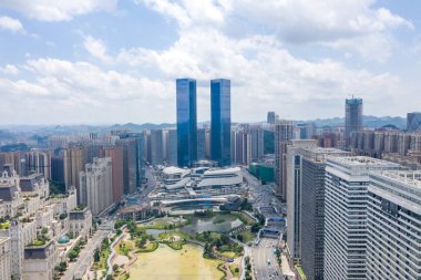 Guizhou Çin şehir manzarası yüksek modern binaları ve bulutlu bir gökyüzünün altında göleti olan bir parkı gösteriyor..