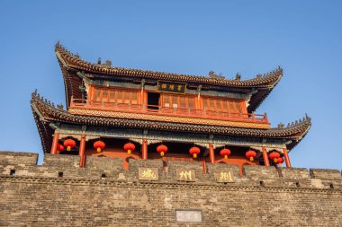 Antik kapı, Çin 'in açık mavi gökyüzünün altında, duvarlarını süsleyen, tarihi ihtişam ve kültür mirasını sergileyen, geleneksel kırmızı fenerlerin yer aldığı, Jingzhou Çin' de dimdik duruyor..