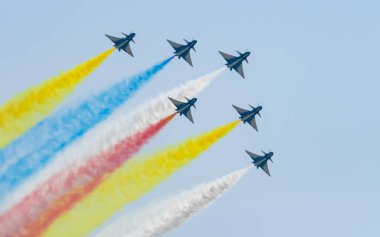 Birkaç jet gökyüzünde renkli dumanlar saçarak diziliş halinde uçar..