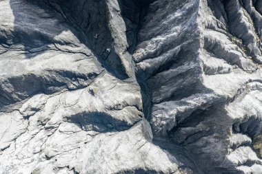 Çin Sichuan arazisi akış çizgileri ve ışık gölgeleriyle kayalık desenler gösteriyor..