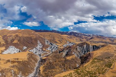 Çin Sichuan Bölgesi Dağları engebeli arazi ve bulutlu gökyüzünü gösteriyor.