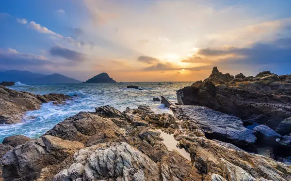 Gün batımında Çin, Shenzhen yakınlarındaki kayalık kıyılara dalgalar çarpar..