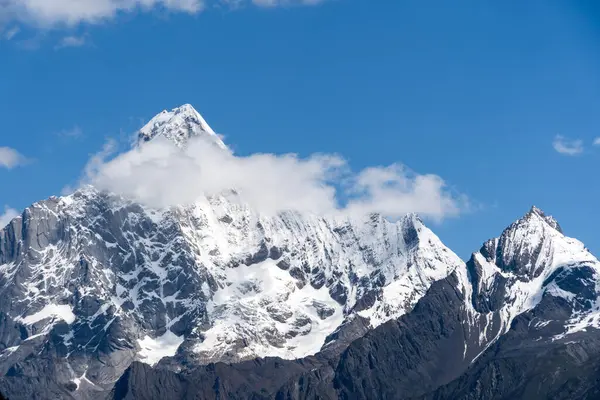 Karlı dağ zirveleri Çin 'in batı bölgesindeki mavi gökyüzüne dokunur..