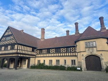 Schloss Cecilienhof 'un dış görünüşü, Tudor tarzı mimarisini ve güzel çevresini gözler önüne seriyor.