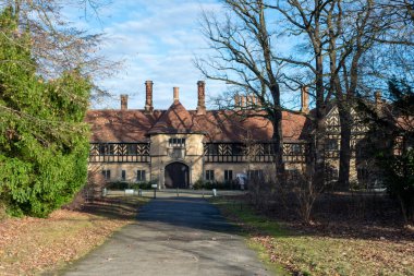Schloss Cecilienhof 'un dış görünüşü, Tudor tarzı mimarisini ve güzel çevresini gözler önüne seriyor.